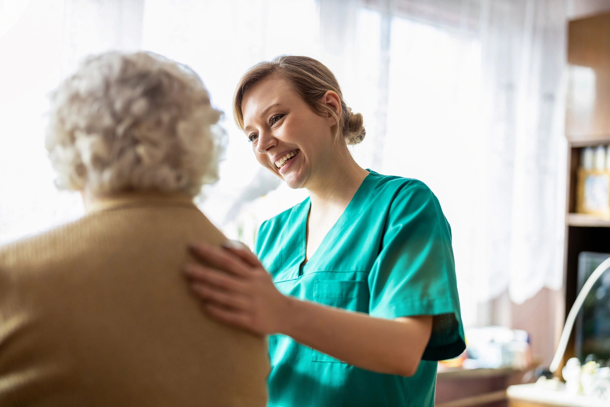 Friendly nurse supporting an elderly lady during recovery at home